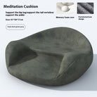 Round ergonomic meditation cushion placed on a yoga mat, with a serene background of plants and candles