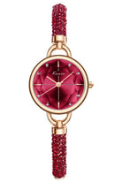 Watch with red dial and beaded strap with rose gold case on white background.