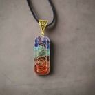 "Colorful chakra stone pendant on a sleek leather strap."